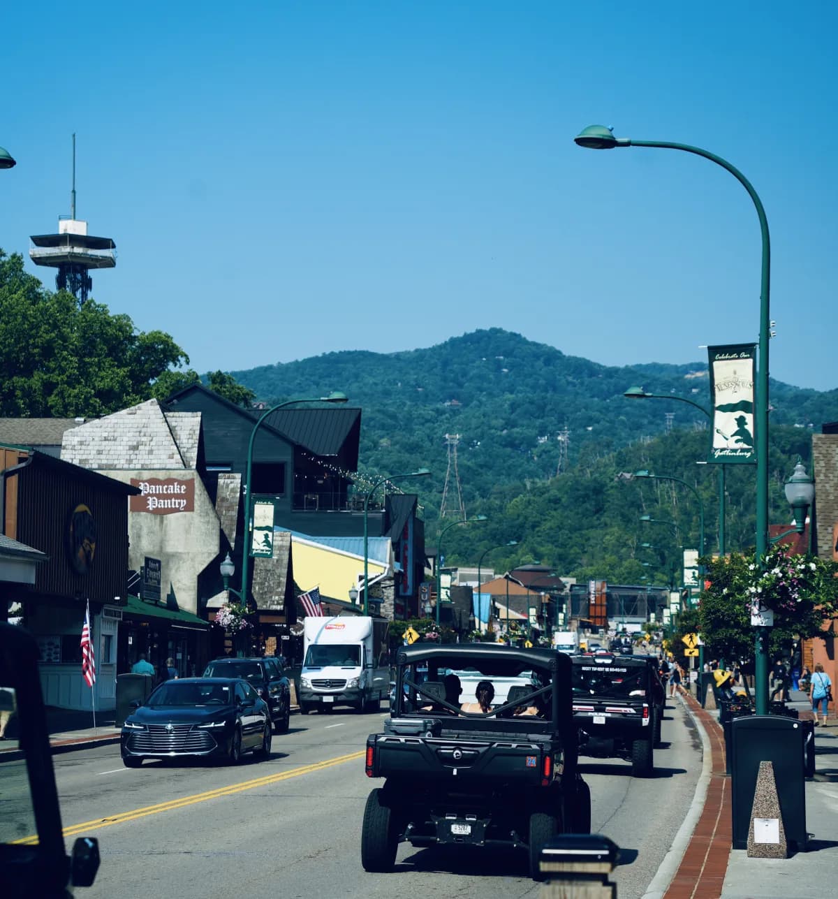 Pancake Pantry sign on a busy street, vehicles driving, mountains in background. at Pancake Pantry in Gatlinburg