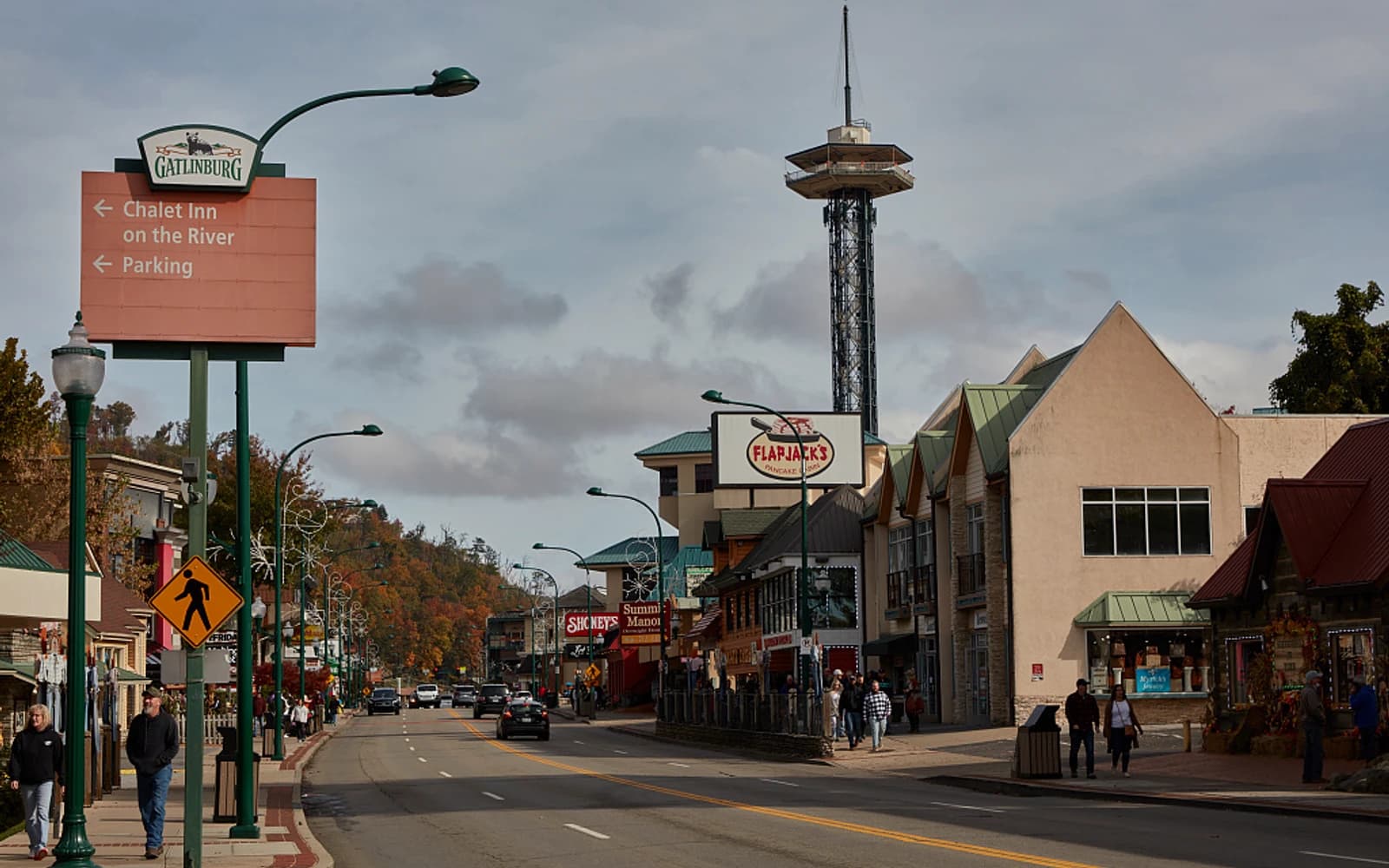 Street scene in Gatlinburg with storefronts and wooded mountains