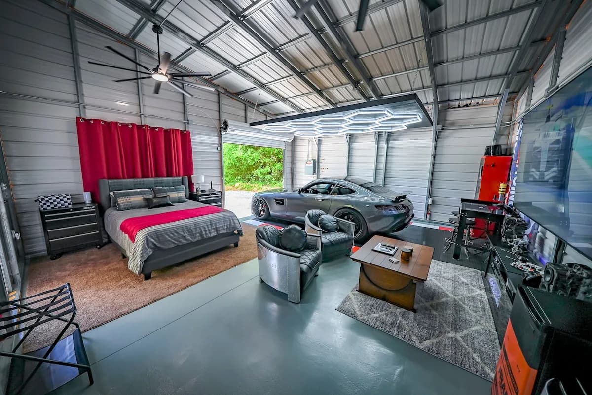 A sports car parked inside BlackTop Lodge Studio right next to the bed